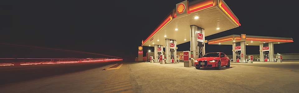 BMW M steht bei Nacht auf einer Shell Tankstelle 